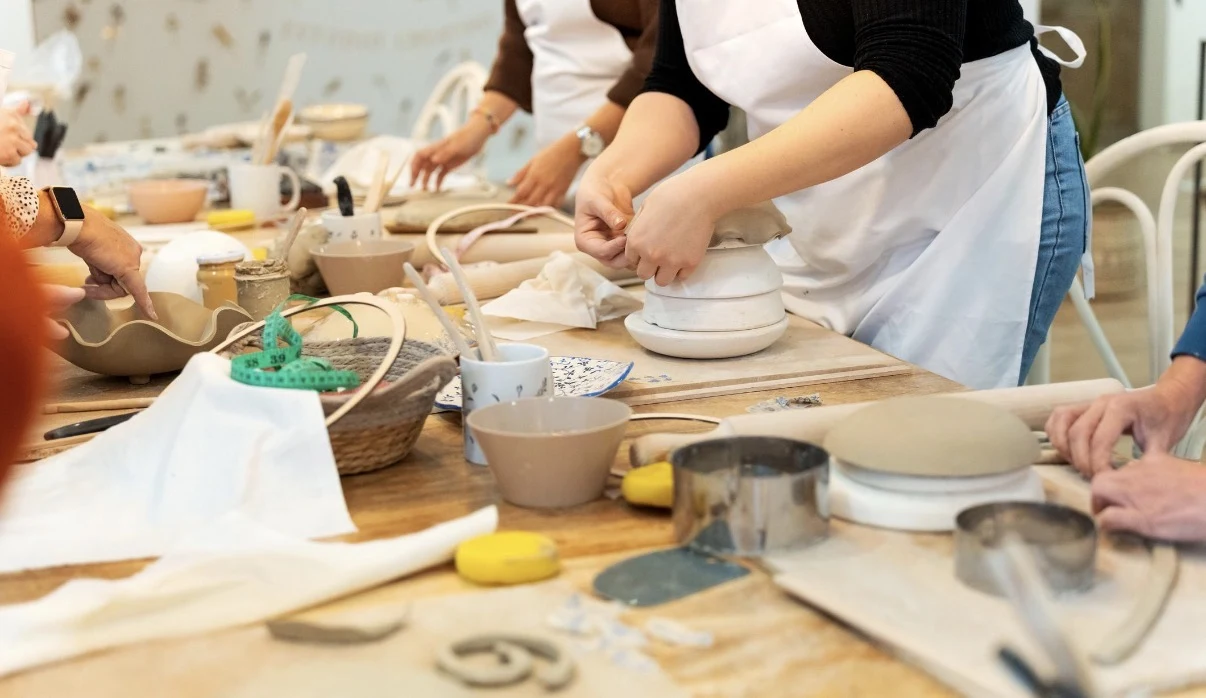 Deelnemers vormen samen keramiek tijdens een groepsworkshop